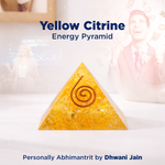 Yellow Citrine energy pyramid with a spiral design on a blurred background
