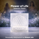 Selenite plates with Flower of Life design on a blurred natural background