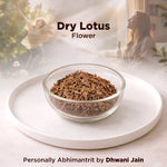 Glass bowl of dry lotus flower on a white surface with a blurred background