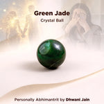 Green jade crystal ball on a white surface with a blurred background