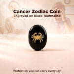 Black tourmaline coin with Cancer zodiac symbol on a soft pink background
