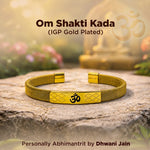 Gold-plated bracelet with Om symbol on a stone surface, blurred nature background