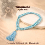 Turquoise crystal mala necklace on a beige background with text indicating brand and creator.