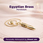 Gold Egyptian Brass Pendulum on a soft fabric background with text overlay.