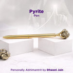 Gold pen with pyrite on a white background, featuring the brand 'Dhwani Jain'.
