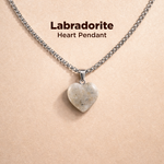 Labradorite heart pendant necklace on a beige background