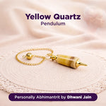 Yellow Quartz Pendulum on a textured surface with branding text.