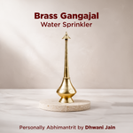 Brass Gangajal water sprinkler on a marble base with a plain background