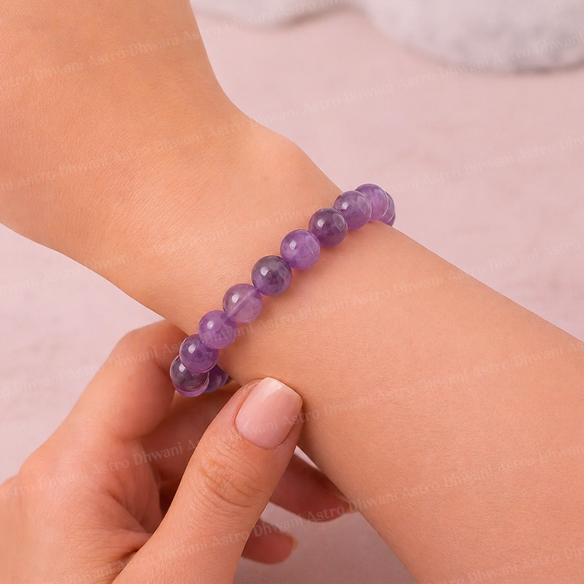 Purple beaded bracelet on a wrist with a plain background