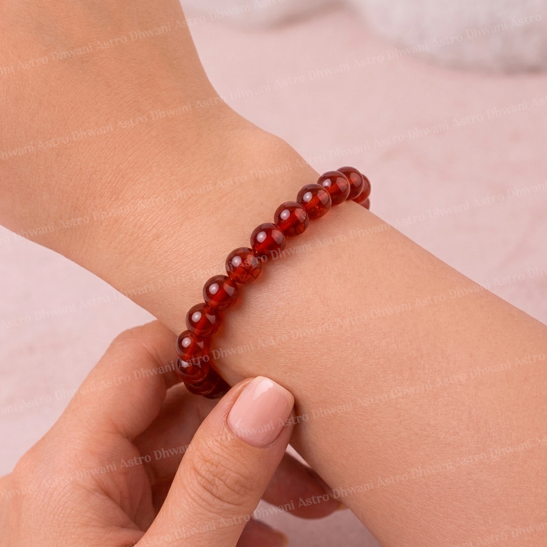 Red beaded bracelet on a wrist with a blurred background