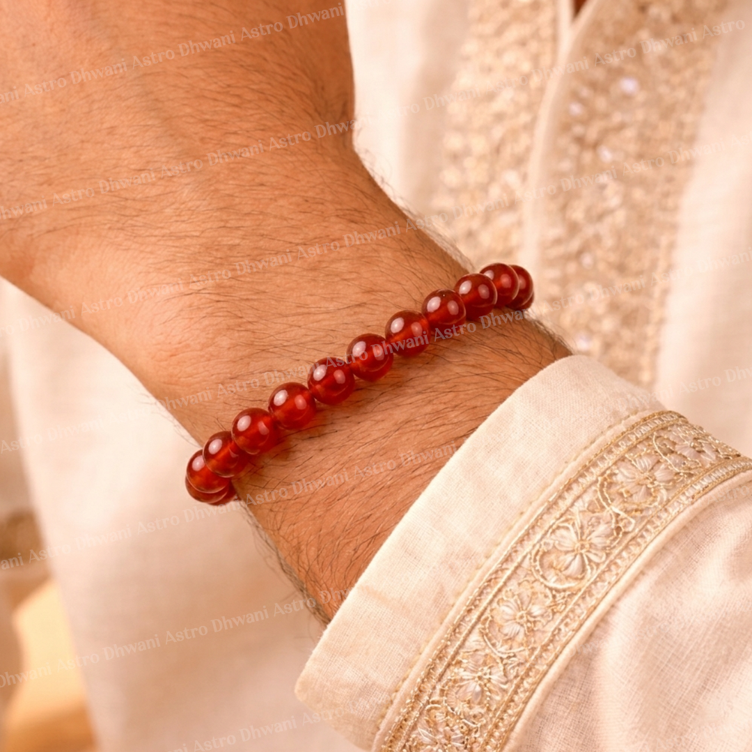 Red beaded bracelet on a wrist with a light-colored garmentRed Carnelian Bracelet for Mangal & Sun Strength (Abhimantrit)