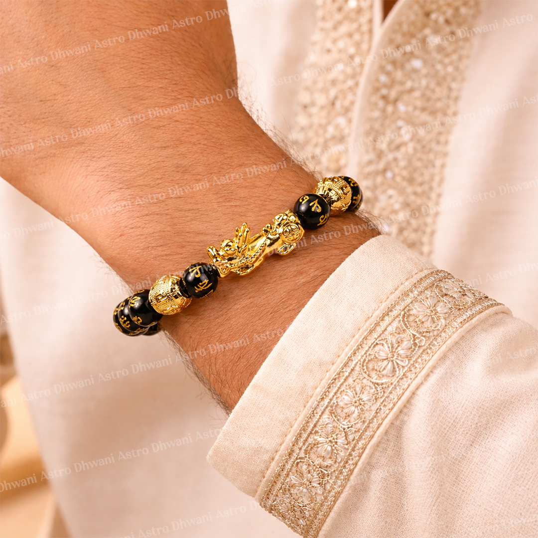 Gold and black beaded bracelet on a wrist with a white garment backgroundप्राकृतिक धन और धन आकर्षित करने वाला कंगन (पिक्सू के साथ फेंग शुई ब्लैक ओब्सीडियन) - अभिमंत्रित और प्रमाणित