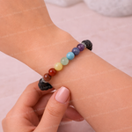 Multicolored beaded bracelet on a wrist with a soft pink background