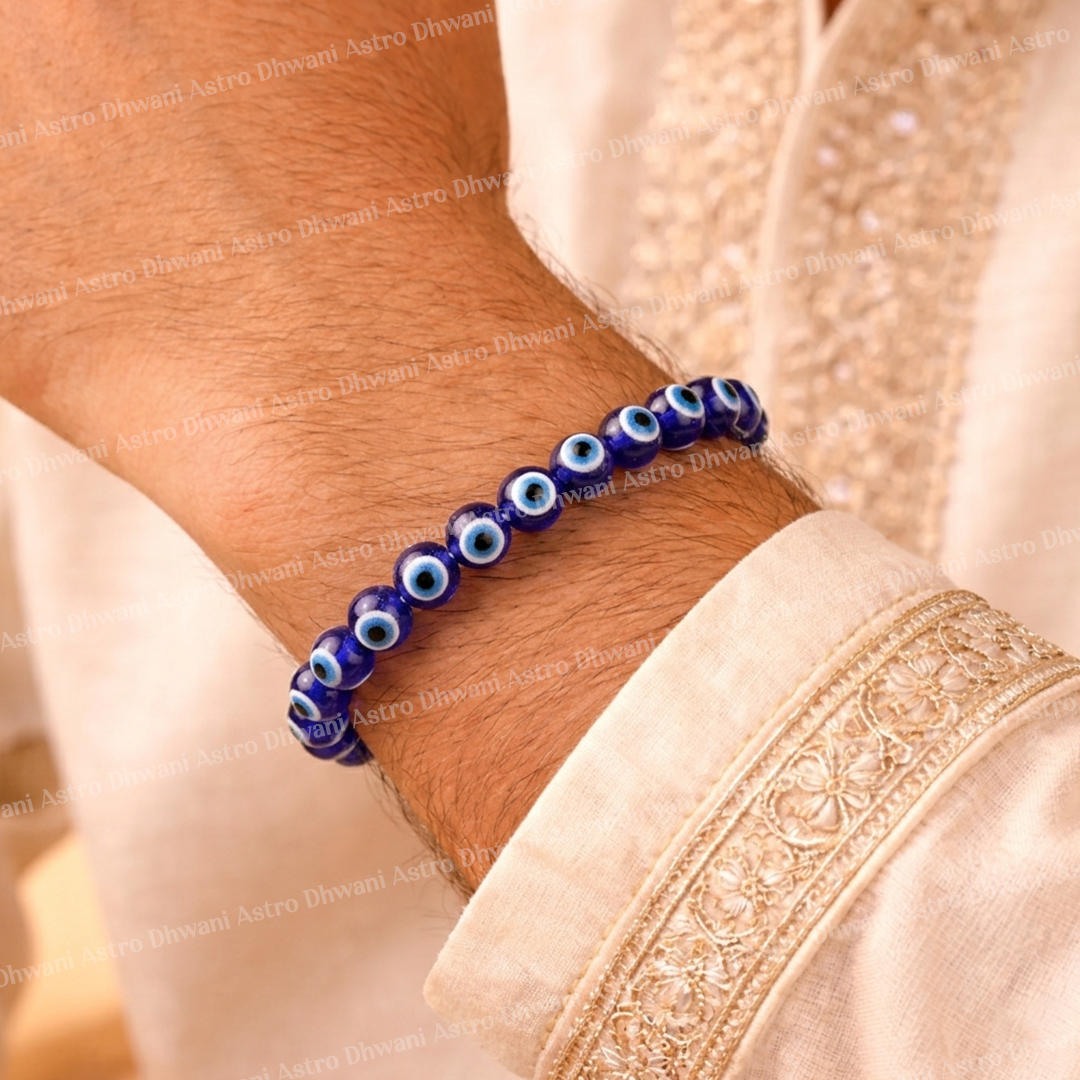 Blue beaded bracelet on a wrist with a beige garment backgroundEvil Eye Bracelet: Protect from Negative Energy & Evil Spirit
