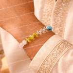 Close-up of a person wearing a bracelet with beads on a light fabric background