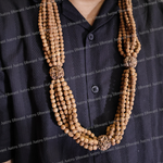 Long necklace with brown beads draped over a dark shirt