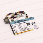 A beaded necklace with a dark gray rectangular pendant featuring a gold Vastu symbol, displayed next to a laboratory certificate card on a white background with faint watermarks.