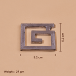 A square metal ornament with a geometric maze-like cutout design, shown on a beige background.