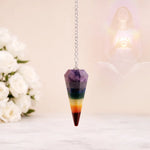 Colorful crystal pendulum on a chain with a soft, blurred background