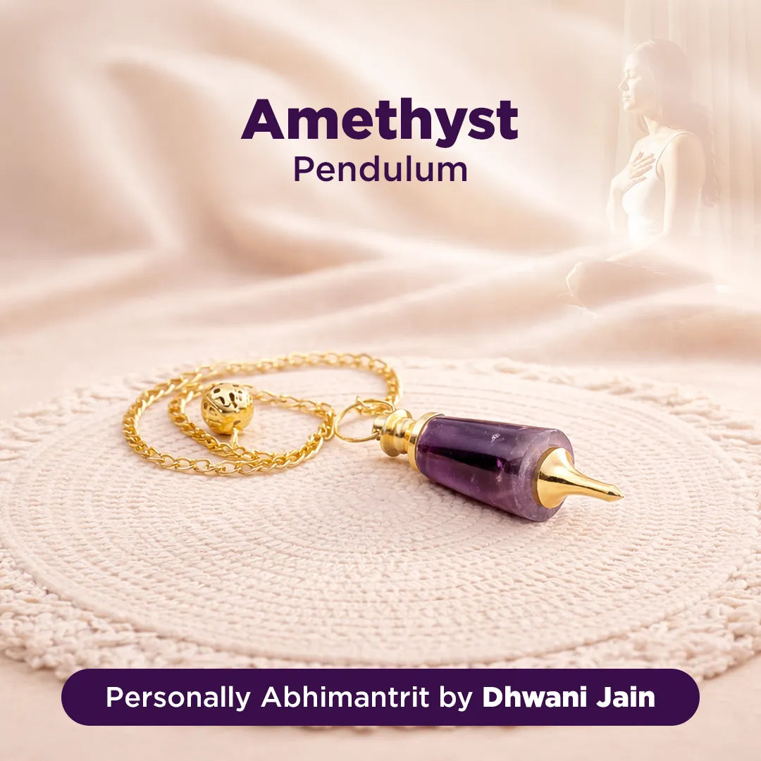 Amethyst pendulum with gold chain on a soft fabric background