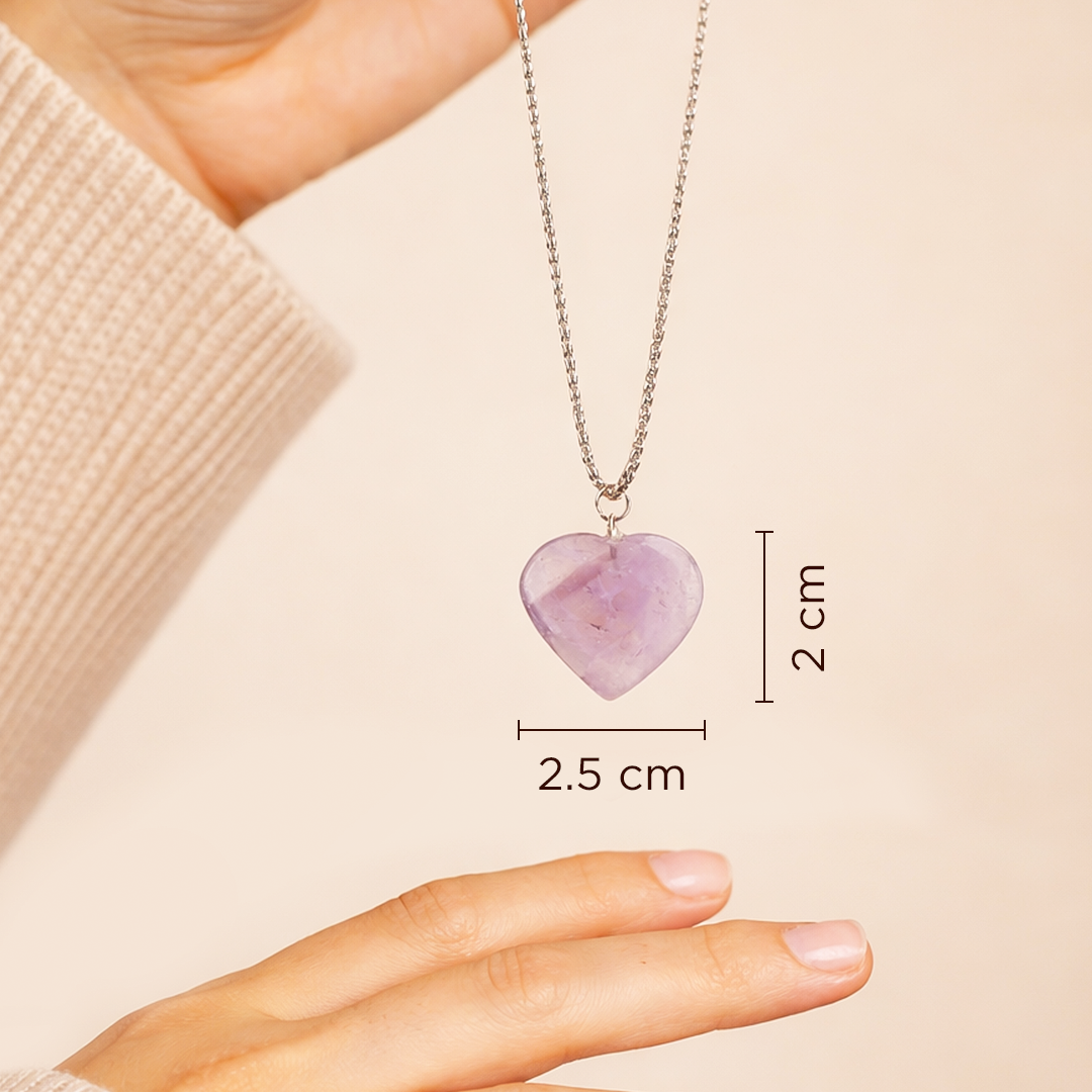 Necklace with a heart-shaped purple pendant held by a hand, showing measurements on a beige background.Amethyst Heart Pendant (Abhimantrit) for Peace & Clarity