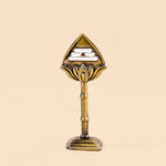 Decorative object with a triangular top and cylindrical base on a beige background