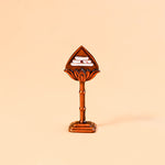 Decorative item with a leaf-shaped top and cylindrical base on a beige background