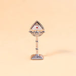Decorative object with a triangular top and cylindrical base on a beige background