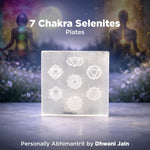 7 Chakra Selenites Plates with a blurred background of two people in meditation.