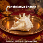 Panchajanya Shankh on a decorative tray with lit lamp and flowers in the background