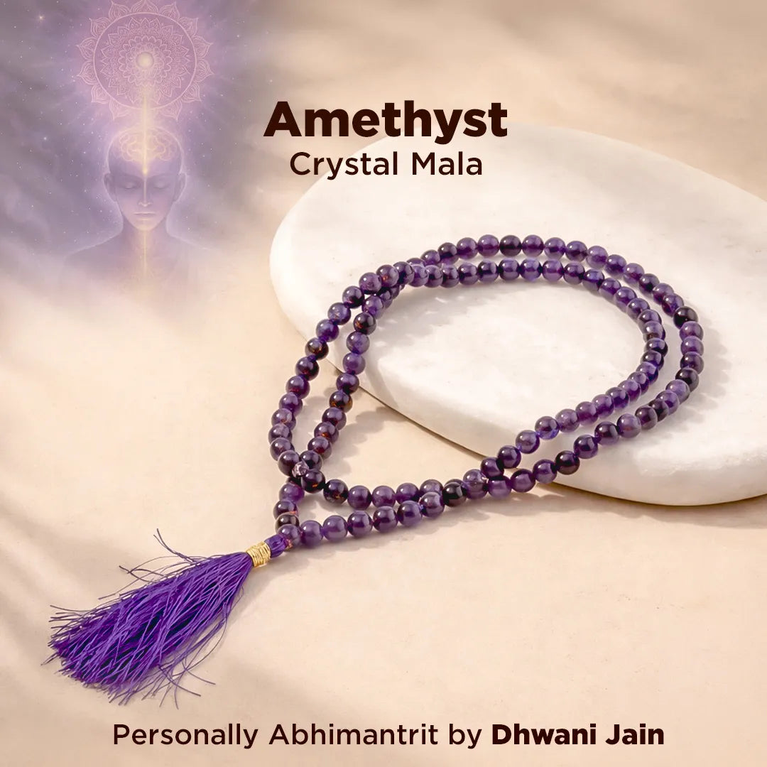 Amethyst crystal mala necklace on a white stone with a blurred abstract design in the background.