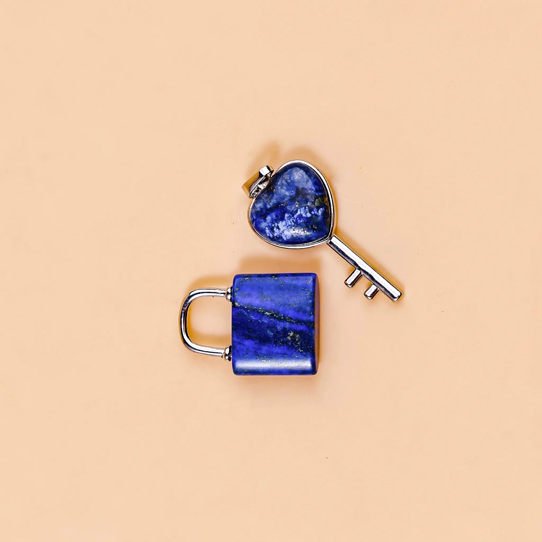 Heart-shaped key and lock with blue stone on a beige background