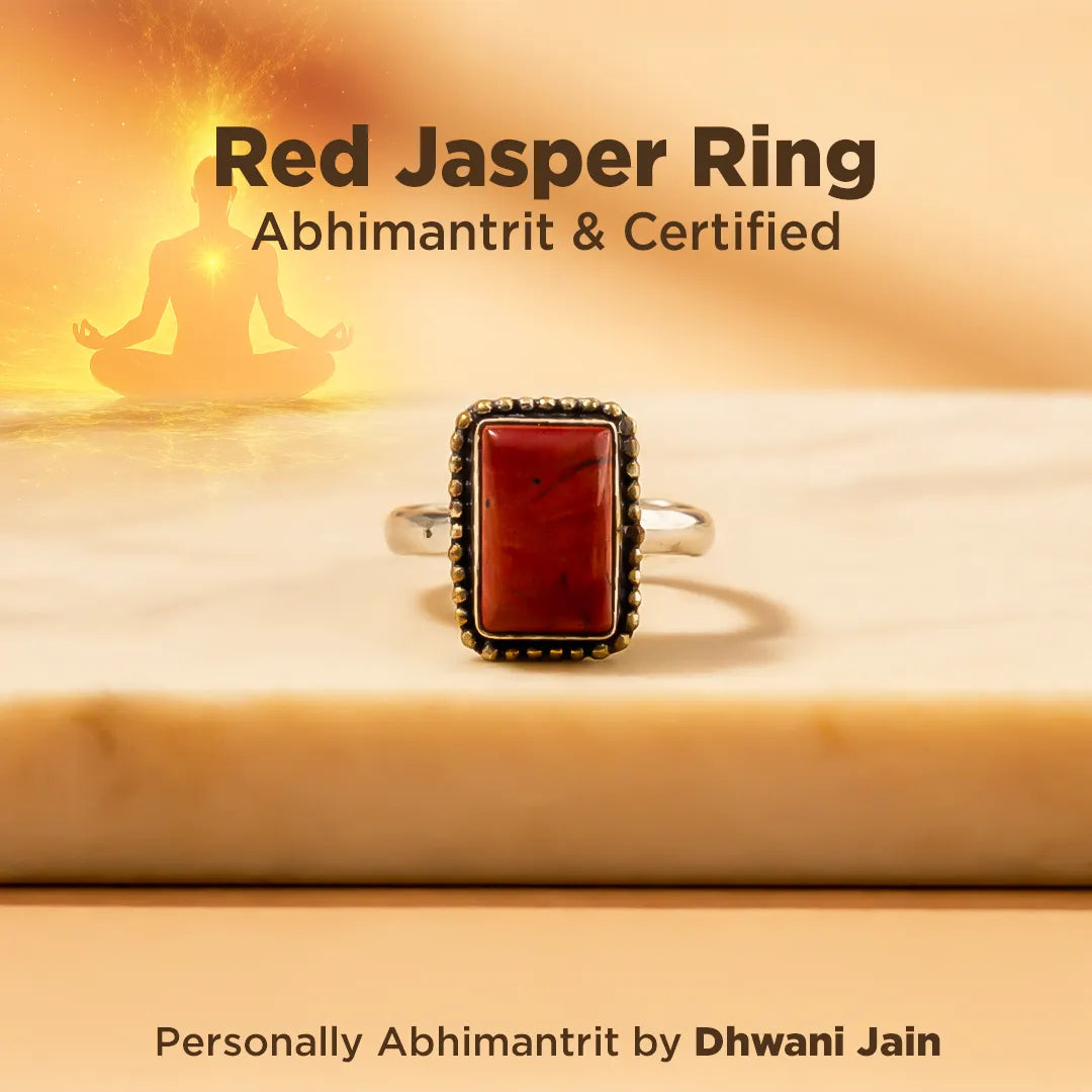 Red Jasper Ring on a wooden surface with a blurred background of a person in meditation.