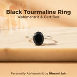 Black tourmaline ring on a wooden surface with text about certification and branding.