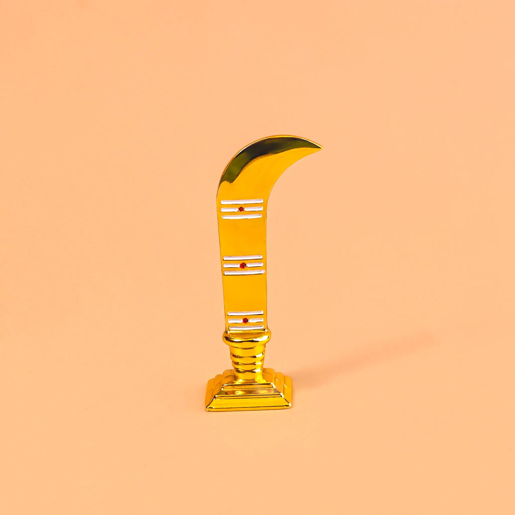 Gold curved object on a peach background