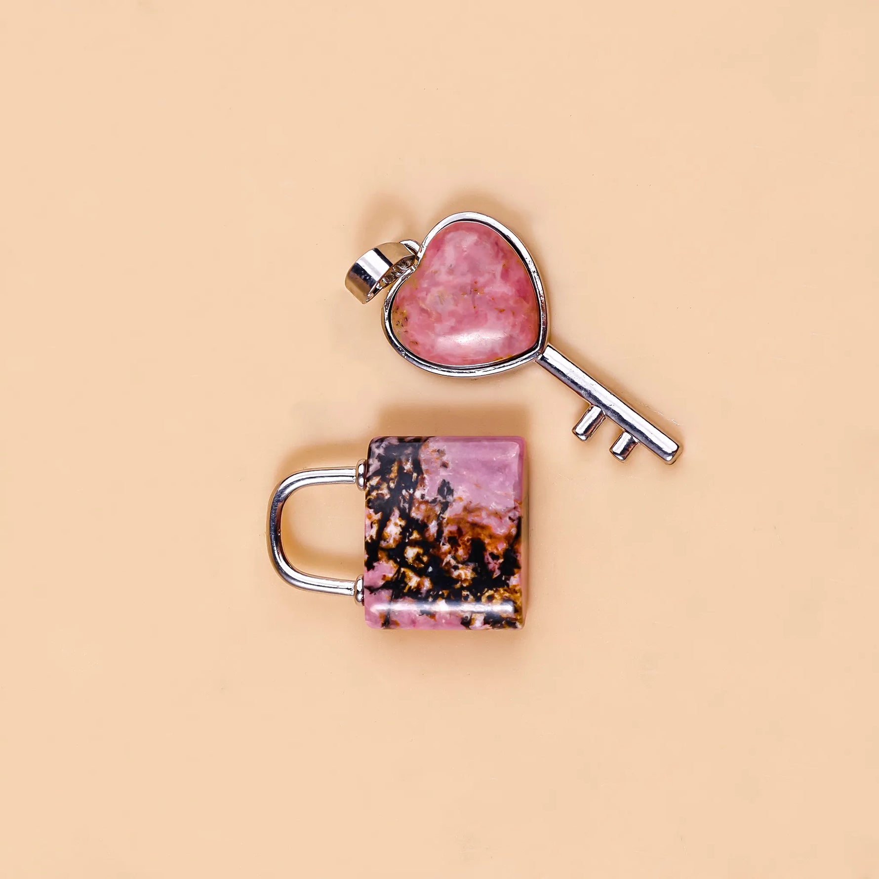 Heart-shaped key and lock charm on a beige backgroundRhodonite Lock And Key Pendant - Abhimantrit & Certified