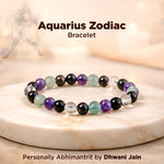 Aquarius Zodiac bracelet with colored beads on a marble surface, featuring the brand 'Dhwani Jain'.