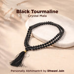 Black tourmaline crystal mala necklace with tassel on a beige background
