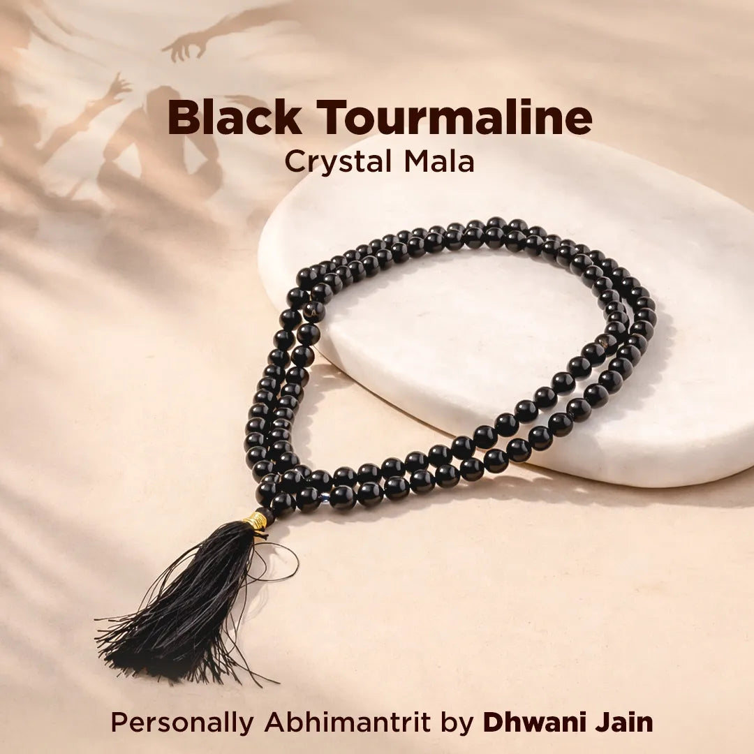 Black tourmaline crystal mala necklace with tassel on a beige background