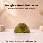Rough natural moldavite on a white surface with a beige background