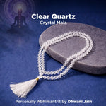 Clear Quartz Crystal Mala on a dark blue background with a silhouette of a person and a mandala.