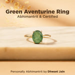 Green aventurine ring with gold band on a beige background, featuring text about certification and branding.