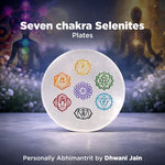 Seven chakra Selenites plates with a blurred background of people and nature.