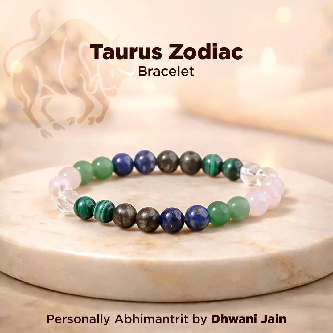 Taurus Zodiac bracelet with colored beads on a marble surface, featuring the brand 'Dhwani Jain'.