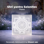 Shri yantra Selenites plate with blurred people and plants in the background