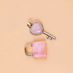 Pink heart-shaped key and lock on a beige background