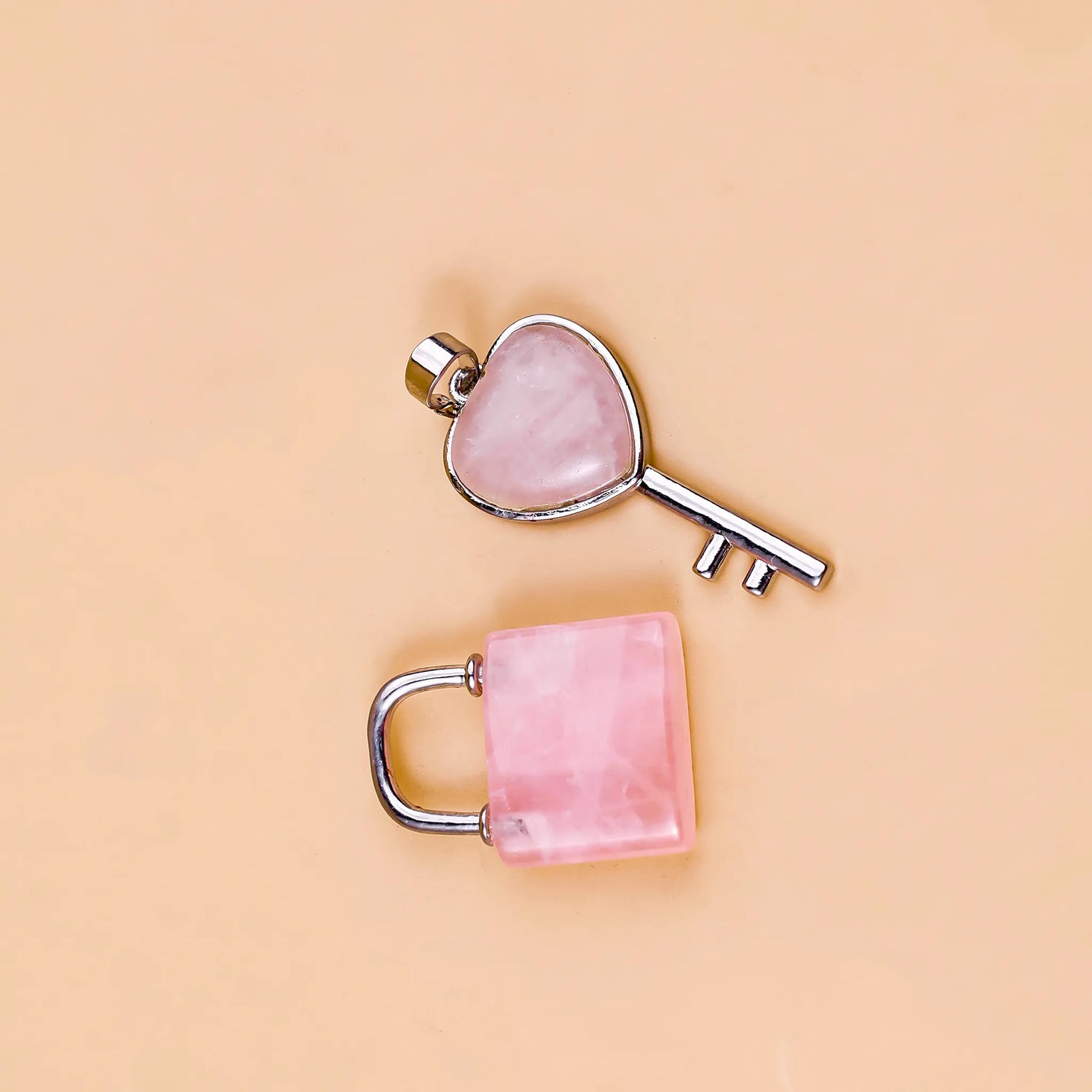 Pink heart-shaped key and lock on a beige background