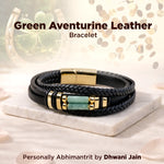Black leather bracelet with green aventurine stone and gold accents on a white surface.