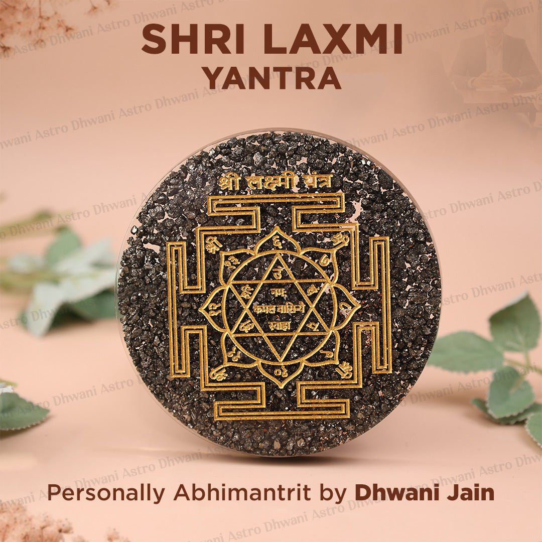 A round black Shri Laxmi Yantra stone with gold-colored geometric and mandala designs, displayed on a soft beige background with decorative leaves and text overlays.