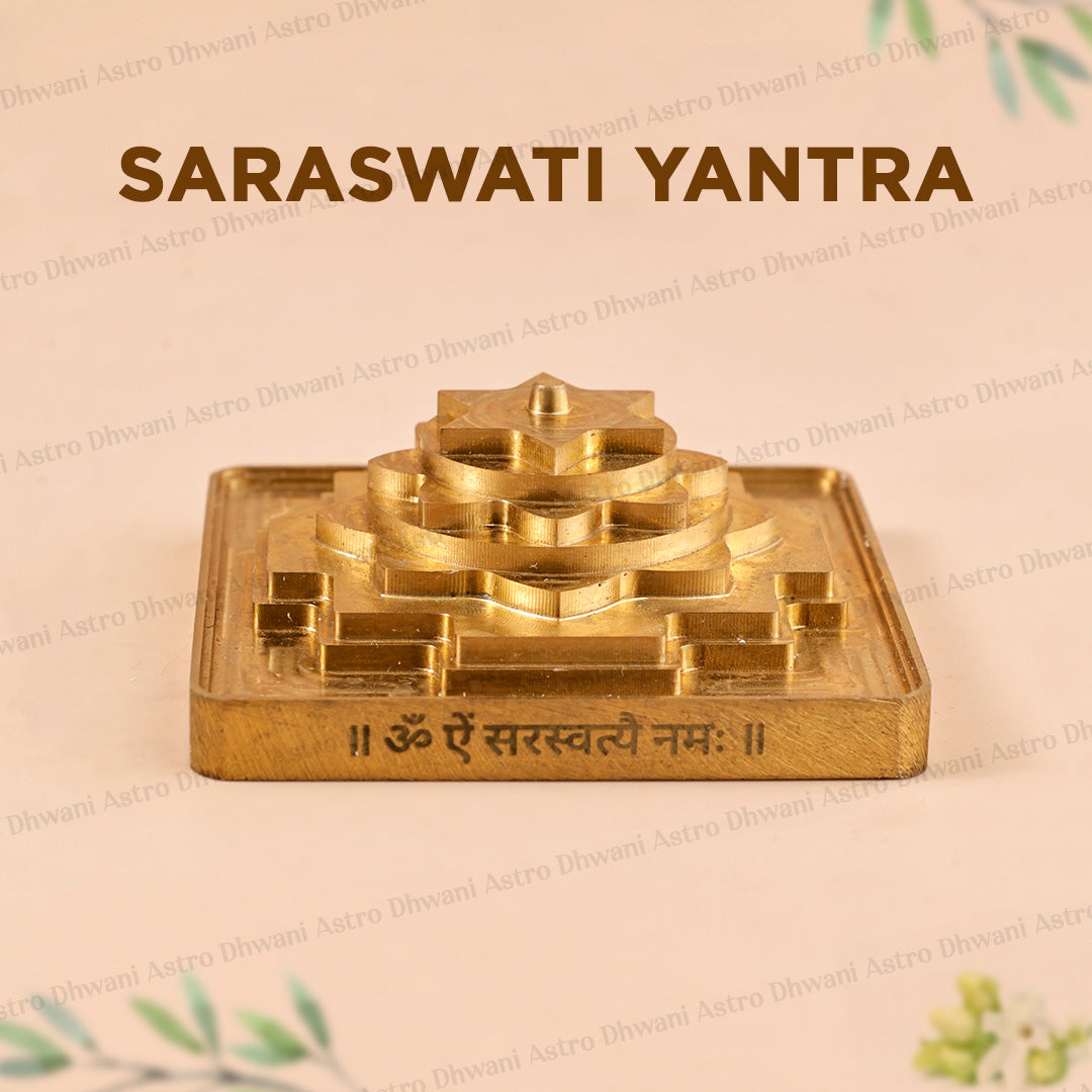 A brass Saraswati Yantra figurine displayed on a light beige background with decorative text and watermarks. The golden metallic yantra features a tiered central structure and a square base engraved with the Sanskrit mantra.